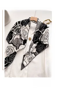 Dettaglio di scialle in velluto con motivo a rose appeso a una gruccia con camicia