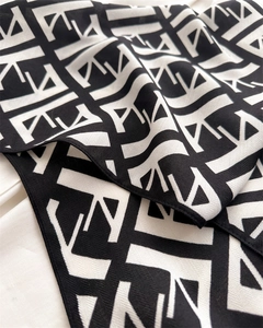 Detailed view of black and white herringbone velvet scarf with geometric letter print