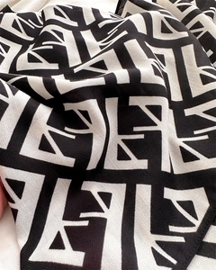 Detailed view of black and white herringbone velvet scarf with abstract geometric print