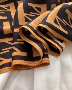 Macro view of velvet scarf showing herringbone texture and classic monogram patterns