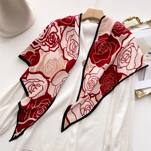 Pashmina in velluto con motivo a rose rosse e bordo nero su gruccia di legno