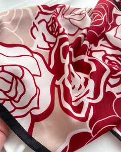 Dettaglio di uno scialle in velluto floreale con motivo di rose rosse e trama in saia