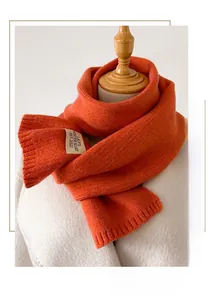 Détail d'une écharpe en maille orange vif avec bord côtelé et texture douce