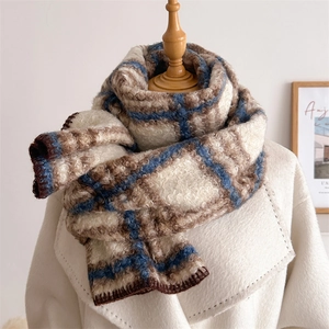 Écharpe écossaise à carreaux bleu et marron en maille bouclée sur manteau en laine beige