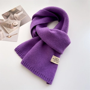 Détail de l'écharpe en tricot violet foncé avec étiquette et texture épaisse à côtes