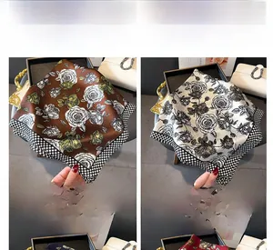 Dettaglio di sciarpe in seta caffè e bianco con stampe di rose e bordi a scacchiera