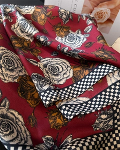 Dettaglio foulard in raso con rose rosse e bordo a scacchi bianco e nero elegante