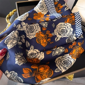 Dettaglio foulard in seta blu navy con rose arancioni e motivi a scacchi blu e bianchi