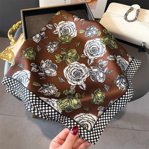 Dettaglio foulard in seta con stampa di rose bianche e bordo a motivo pied-de-poule