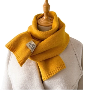 Écharpe en tricot jaune minimaliste avec étiquette vintage sur un mannequin