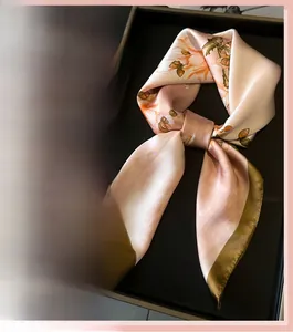 Close-up of pink silk scarf with orange floral pattern and olive green edges
