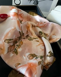 Detail of silk-like satin scarf featuring floral prints and fine rolled hem edges