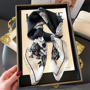 Elegant silk-like scarf with black and white rose floral print shown in a gift box