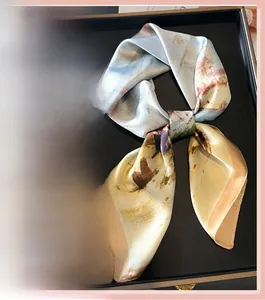 Détail d'un foulard carré effet soie avec imprimé peinture à l'huile et bords champagne