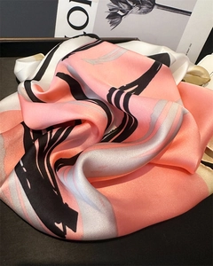 Detail of silk-like satin scarf featuring abstract pink and grey fluid ink pattern