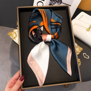 Elegant silk-like square scarf with colorful geometric patterns in a gift tray