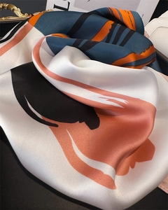 Close-up of abstract artistic print on silk square scarf with vibrant satin texture