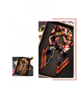 Détail de foulards carrés aspect soie avec motifs paisley vintage dans une boîte