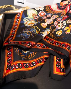 Détail d'un carré de soie satinée avec des motifs floraux ethniques et paisley colorés