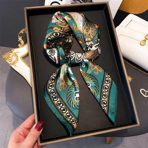 Détail d'un foulard en soie à imprimé floral vintage noué en nœud dans un coffret cadeau