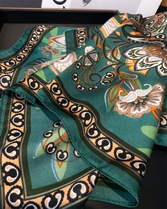 Gros plan d'un foulard en soie vintage avec motifs floraux et finitions baroques