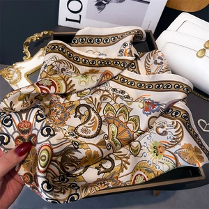 Détail d'un foulard en soie beige avec des motifs floraux paisley sophistiqués