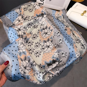 Vue détaillée du foulard en satin à motif floral élégant avec pois bleus et rose