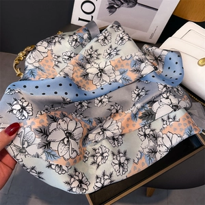 Détail d'un foulard en soie imprimé avec des motifs floraux et des pois sur tissu élégant