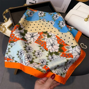 Détail montrant la texture soyeuse et l'imprimé floral éclatant du foulard