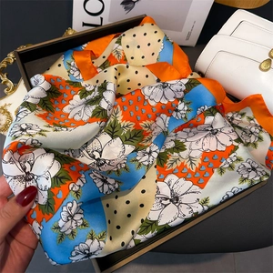 Gros plan détaillé d'un foulard en soie imprimé avec motifs floraux et cœurs colorés