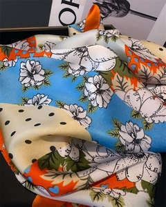 Gros plan sur un foulard en satin à imprimé floral avec des détails de couture fins