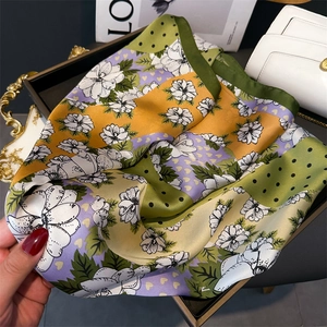 Détail d'un foulard en soie avec imprimés floraux sur un plateau de luxe