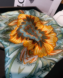 Detail of silk-like square scarf featuring retro orange floral print on light blue fabric