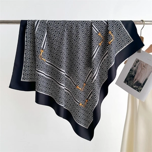 Dettaglio di un foulard in seta con motivo geometrico e stampa di morsetto dorato