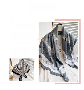 Detail of silk-feel scarf with geometric print and navy border styled as a shawl