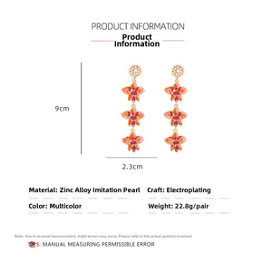 Détail de boucles d'oreilles fleuries montrant les dimensions de 9cm de haut et 2,3cm