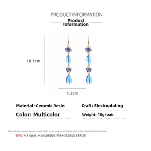 Detailed view of resin and ceramic drop earrings with dimensions of 10.1cm by 1.3cm