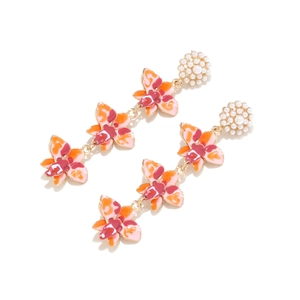 Détail de boucles d'oreilles en émail à trois fleurs avec clou élégant en perles