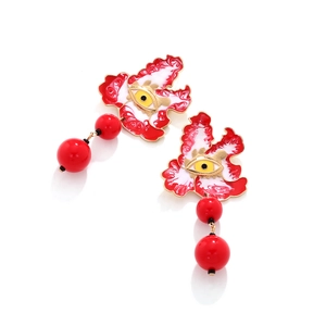Close-up of enamel evil eye earrings featuring red flower motifs and dangling beads