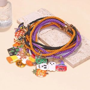 Detail of colorful woven Halloween bracelets featuring pumpkin, ghost, and skull charms