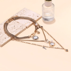 Detail view of multi-layer gold necklace featuring heart pendants and a vintage key