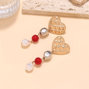 Detail of gold quilted heart earrings with red beads and baroque pearl pendants