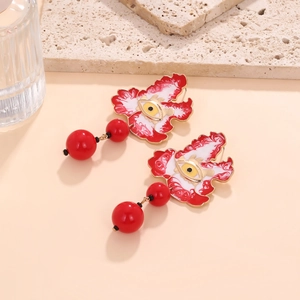 Detail view of colorful enamel evil eye drop earrings with red flame patterns and beads