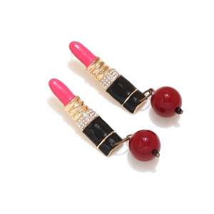 Detail of creative lipstick drop earrings with sparkling rhinestones and red beads