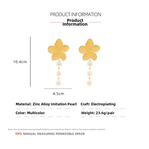 Vue détaillée des boucles d'oreilles fleur dorées avec perles baroques et dimensions