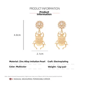 Détail des boucles d'oreilles scarabée avec dimensions 4,8cm x 2,1cm et perles nacrées