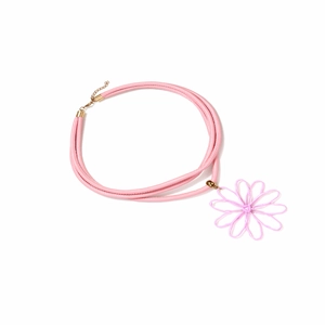 Collier en cordon rose avec pendentif fleur tissée et fermoir doré sur fond blanc pur