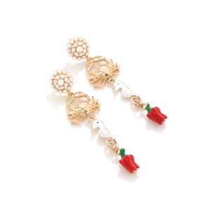 Detailed view of seahorse and crab dangle earrings with red pepper and pearl accents