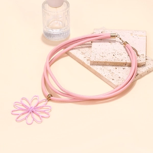 Détail du ras de cou rose multicouche avec pendentif fleur et fermoir doré
