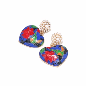 Macro detail of enamel heart earring showing vibrant hand-painted bird and floral patterns